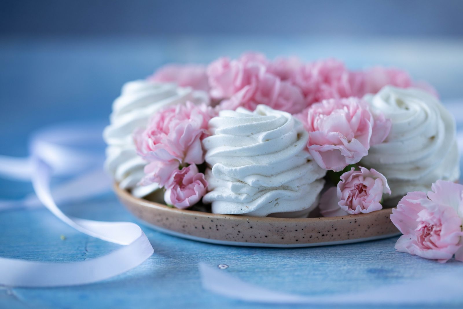 Pink-and-white dessert plated with flowers on a stand