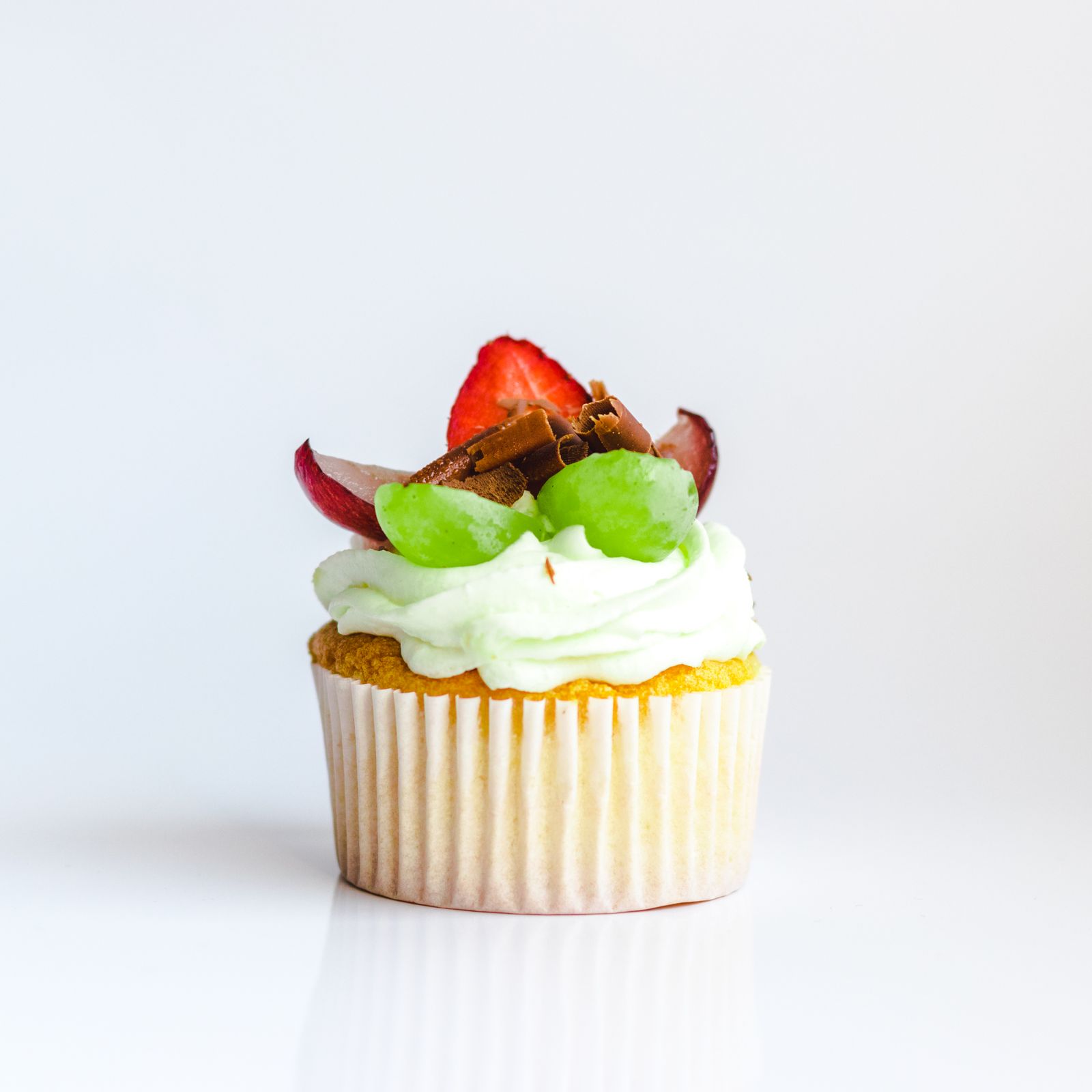 Buttercream cupcake topped with a fresh strawberry