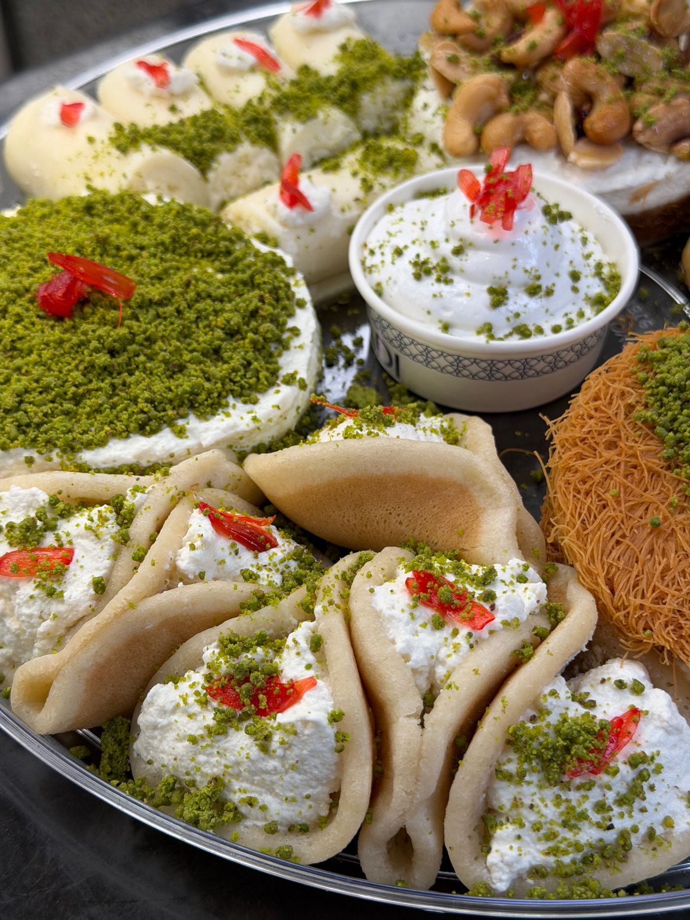 Tray of Persian pastries topped with pistachio and cream