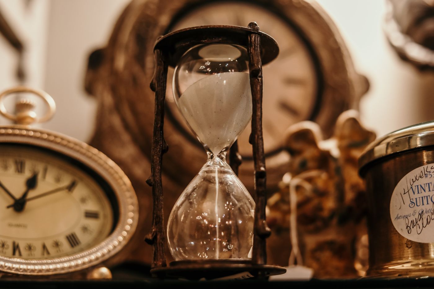 Hourglass and pocket watch on wood