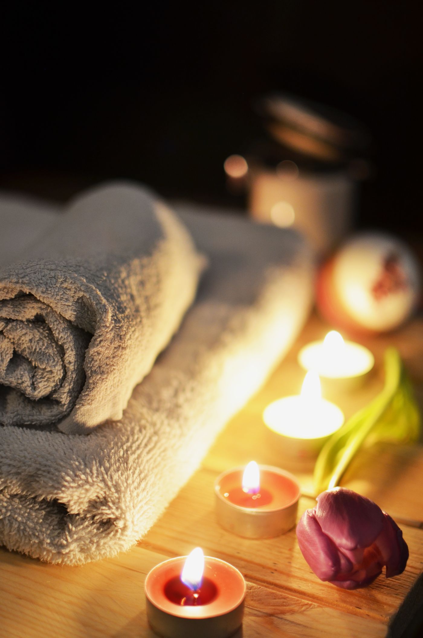 Calm candle-lit spa corner with rolled towel