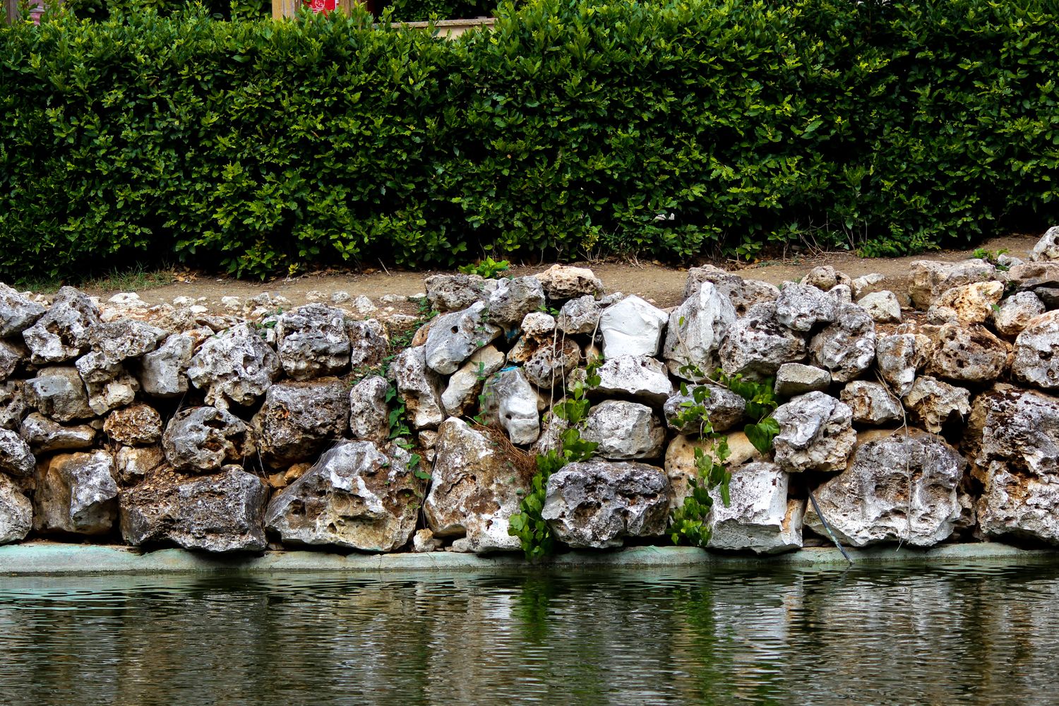 A natural-stone retaining wall holding a planted slope