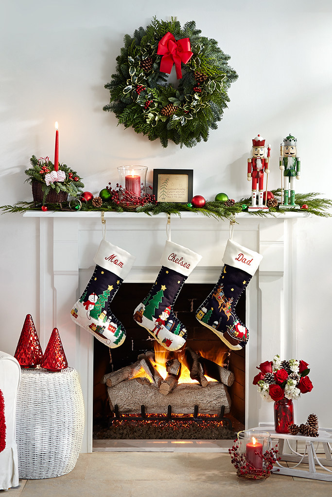 A white mantel fireplace with a lit gas-log fire