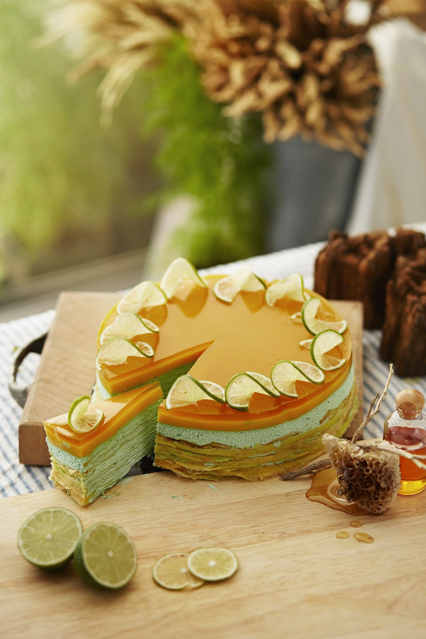 A vibrant layered mousse cake decorated with citrus