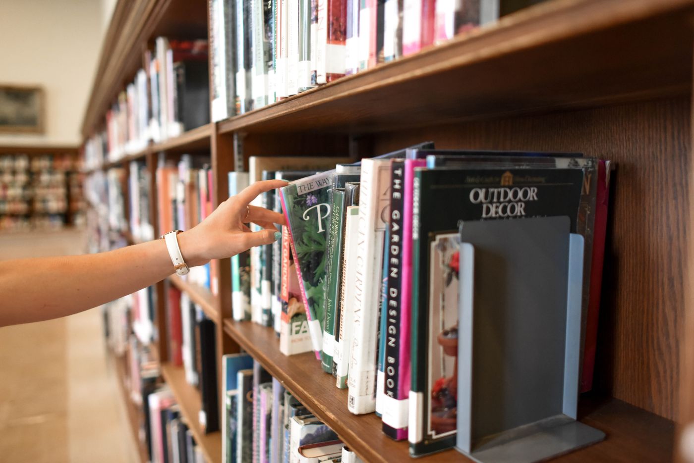 A hand pulling a book from a shelf