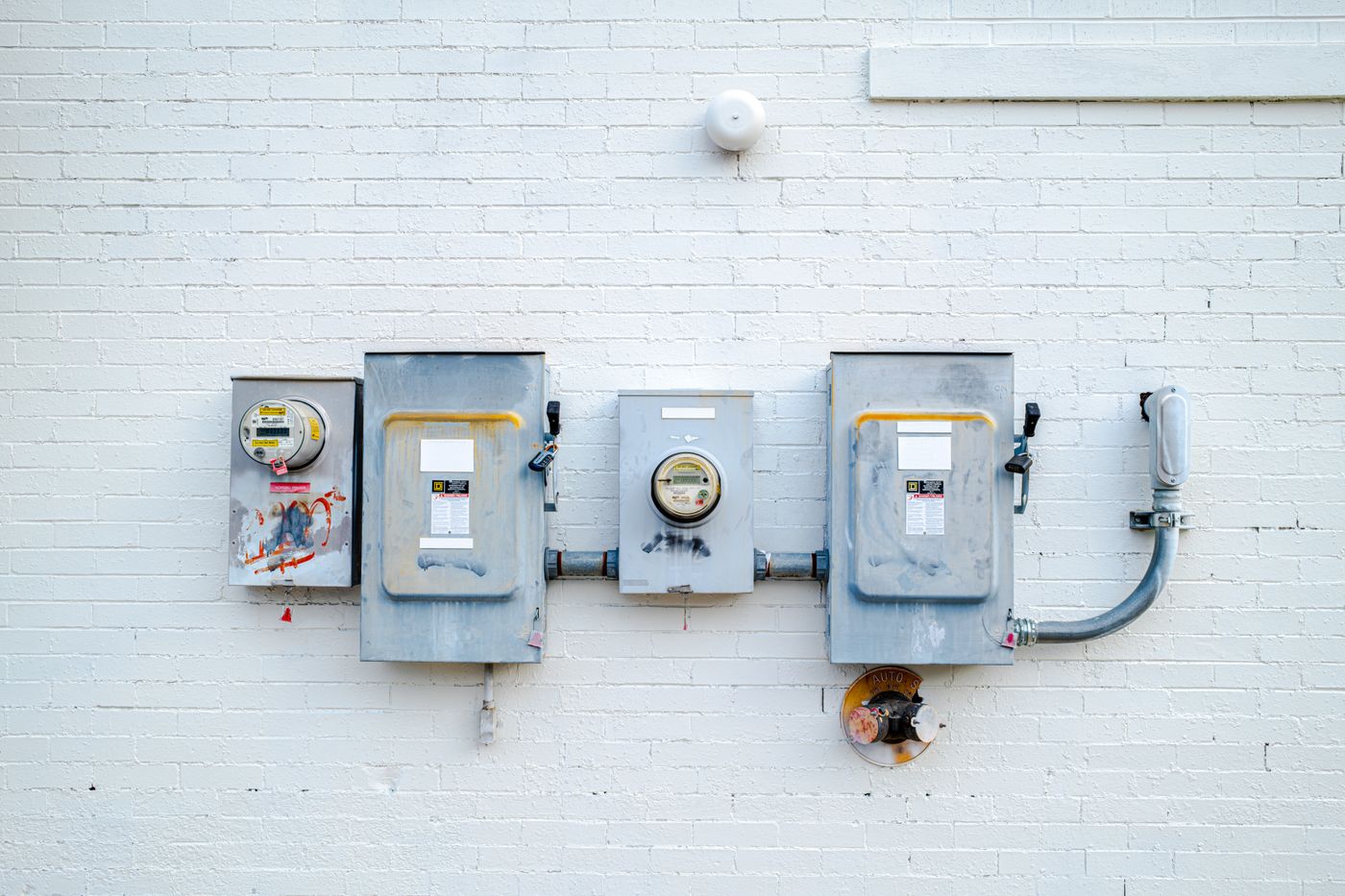 Exterior service meters on a painted brick wall