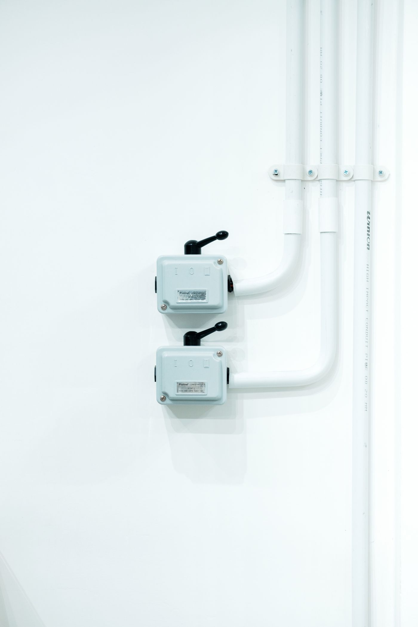 Clean surface conduit and switch gear on a white wall