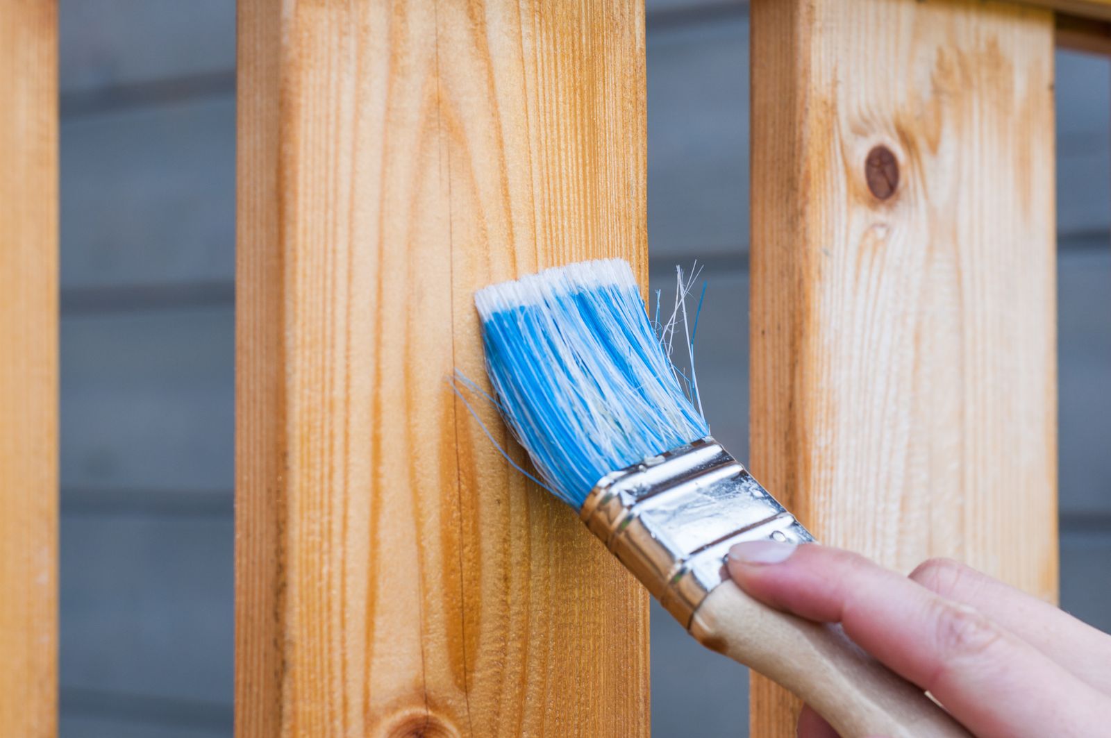 A brush laying a fresh coat on wood trim