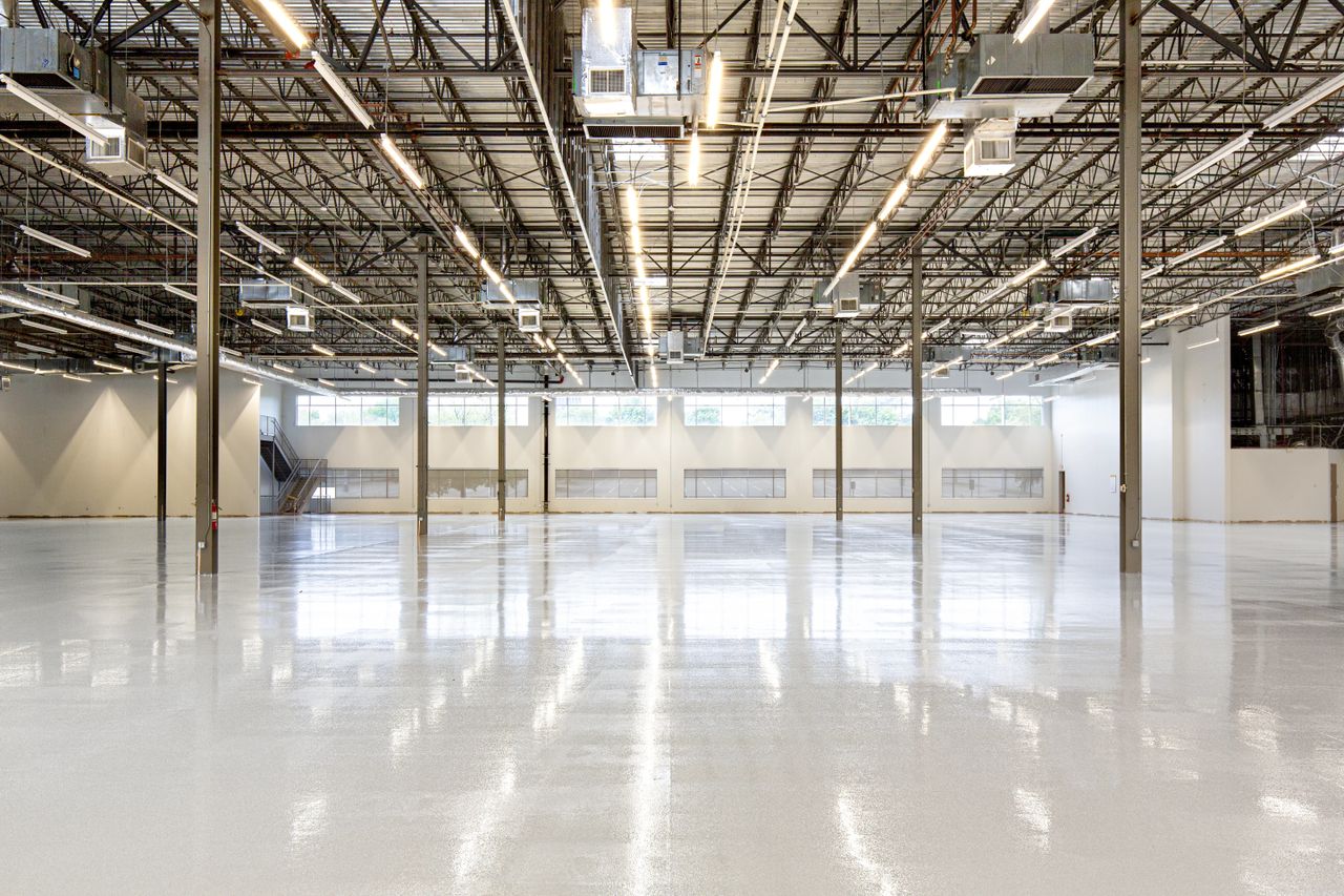 A glossy epoxy-coated warehouse floor reflecting the overhead lights