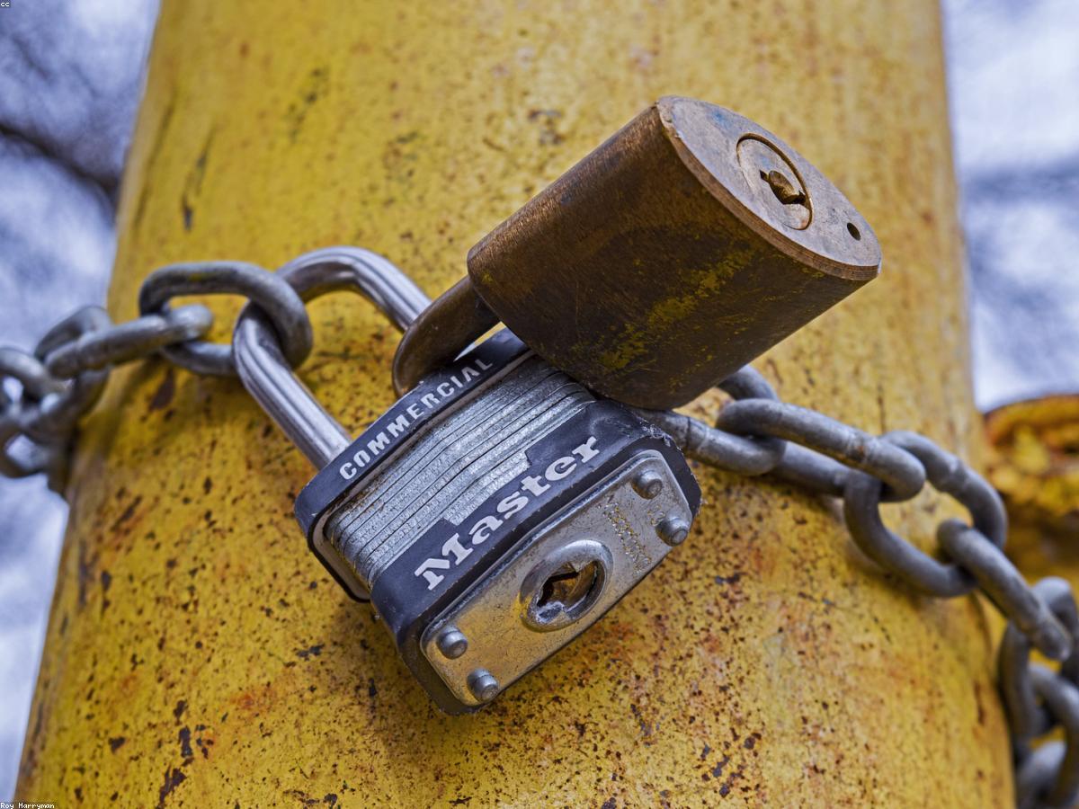 A commercial padlock securing a chain