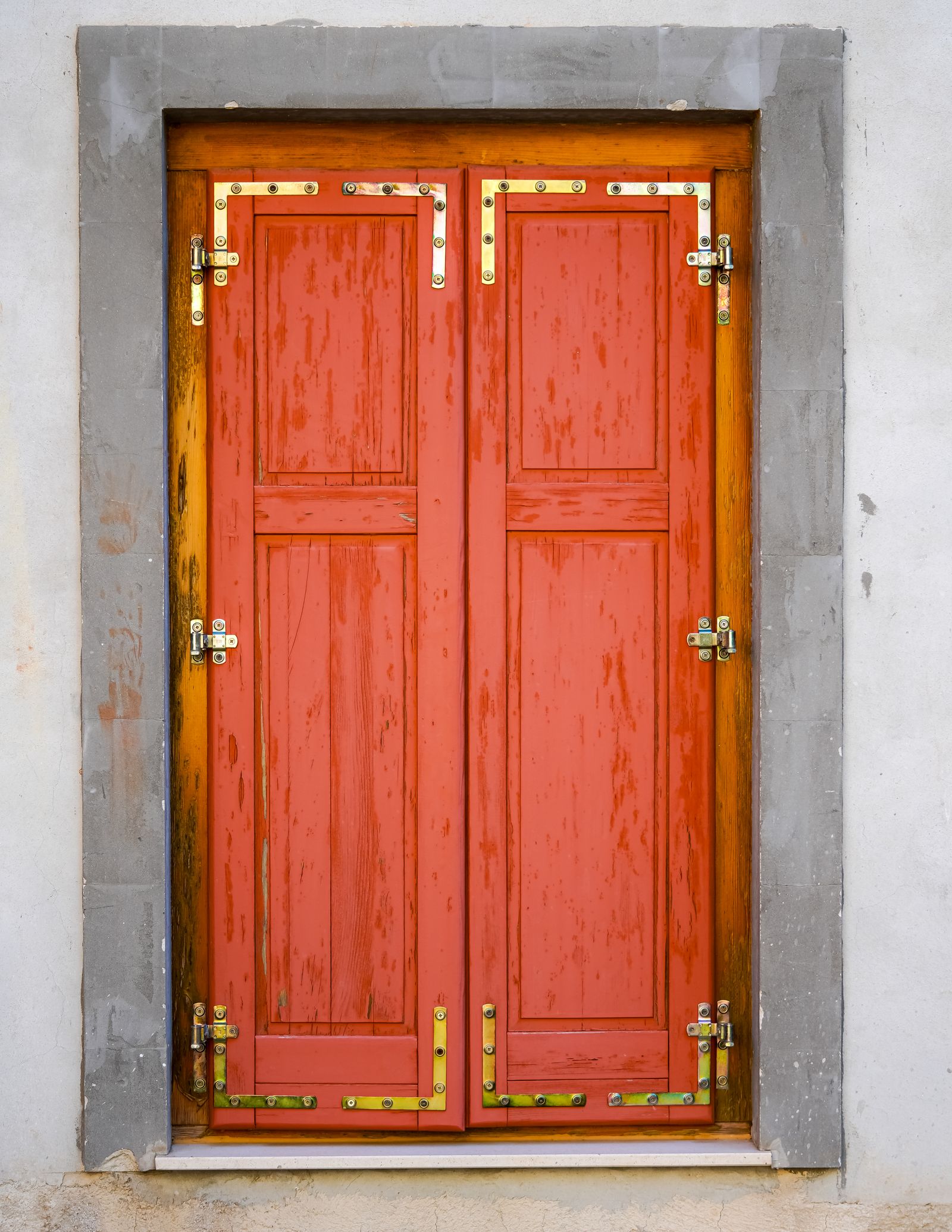 A red entry door with brass lock hardware
