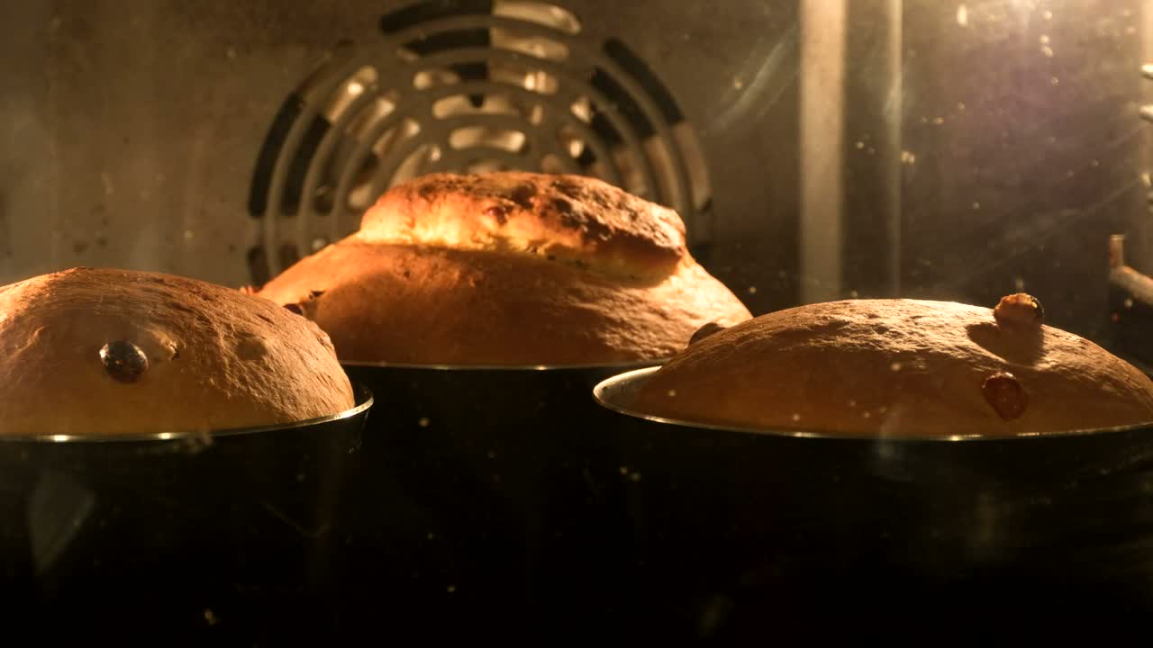 Loaves rising and colouring inside a hot bakery oven