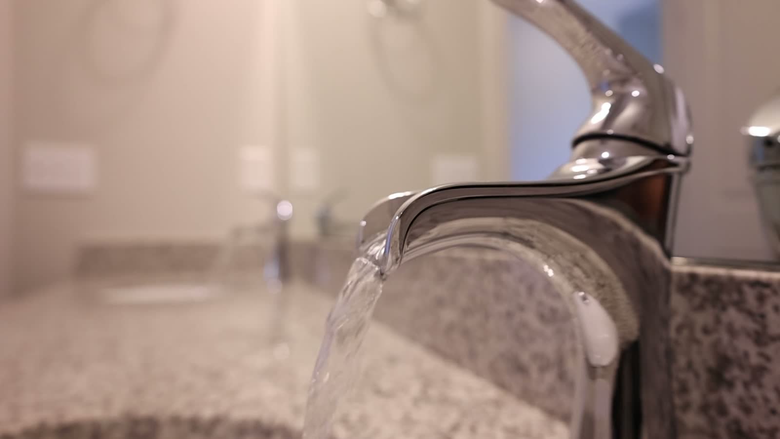 Water flowing from a faucet over a granite countertop